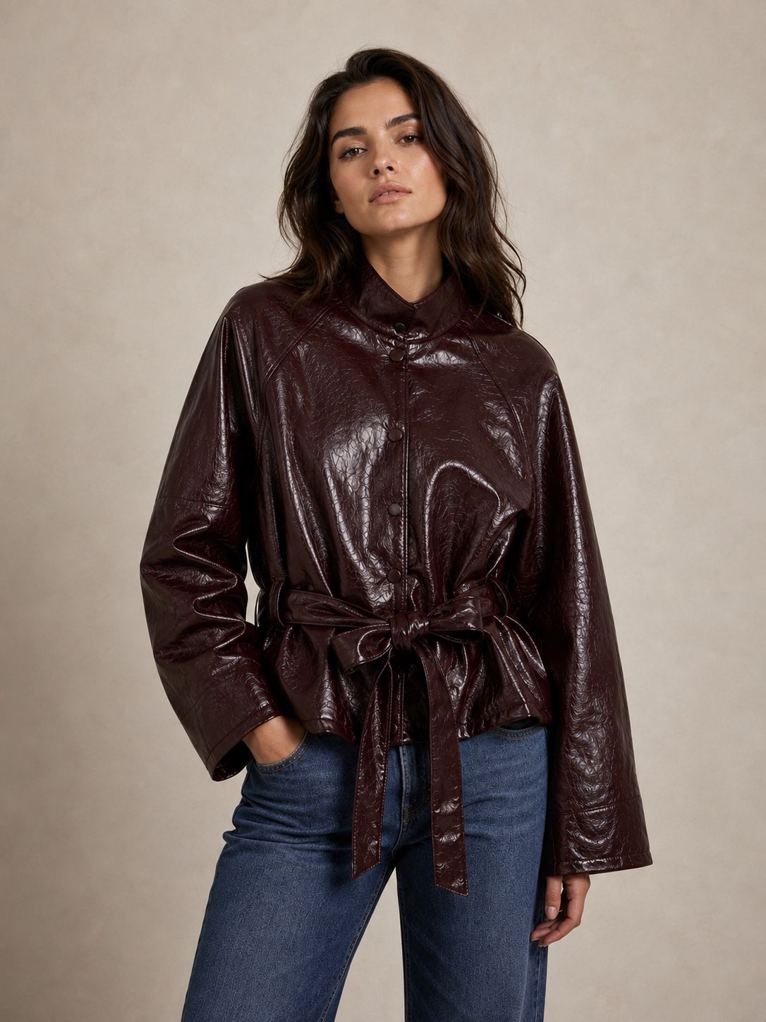 Veste NOÉMIA effet cuir noire à ceinture nouée, portée avec un jean