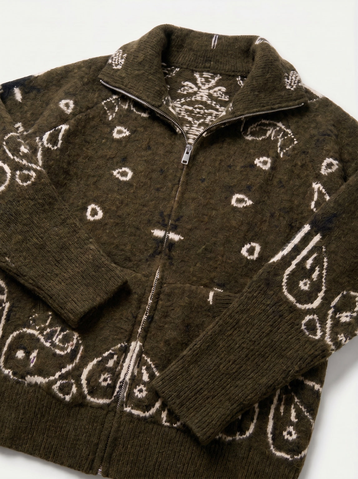 Détail du gilet BANDANA kaki : col ouvert, motifs écrus, poches et finitions côtelées des manches.