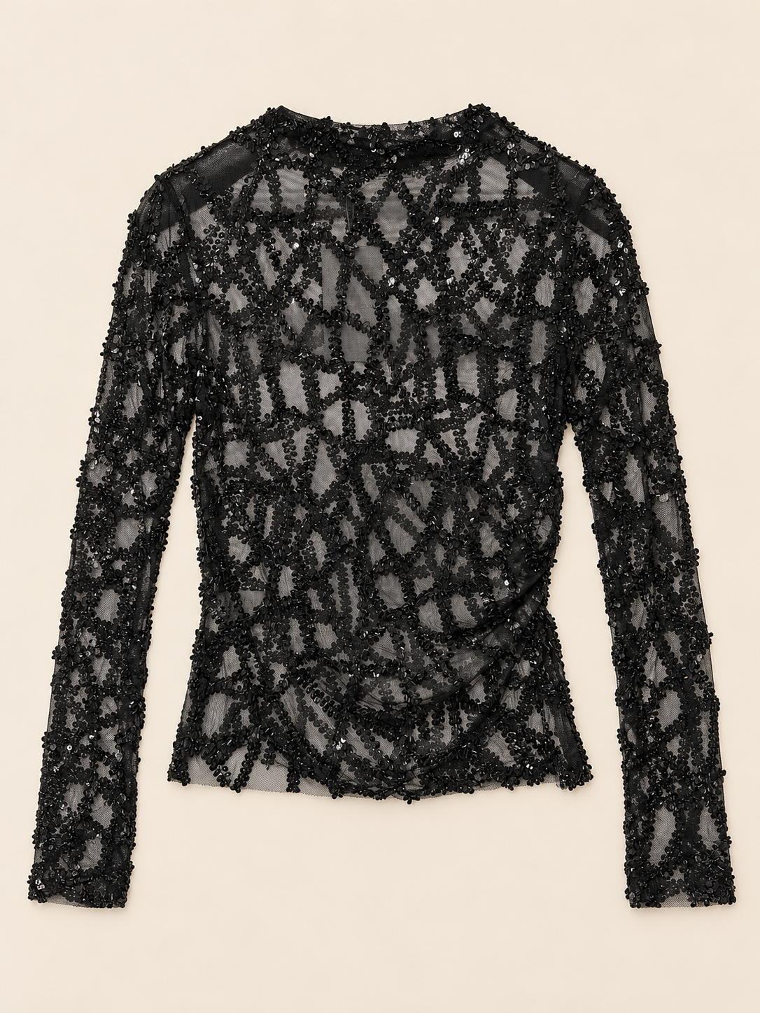 Top noir transparent à sequins photographié à plat sur fond beige