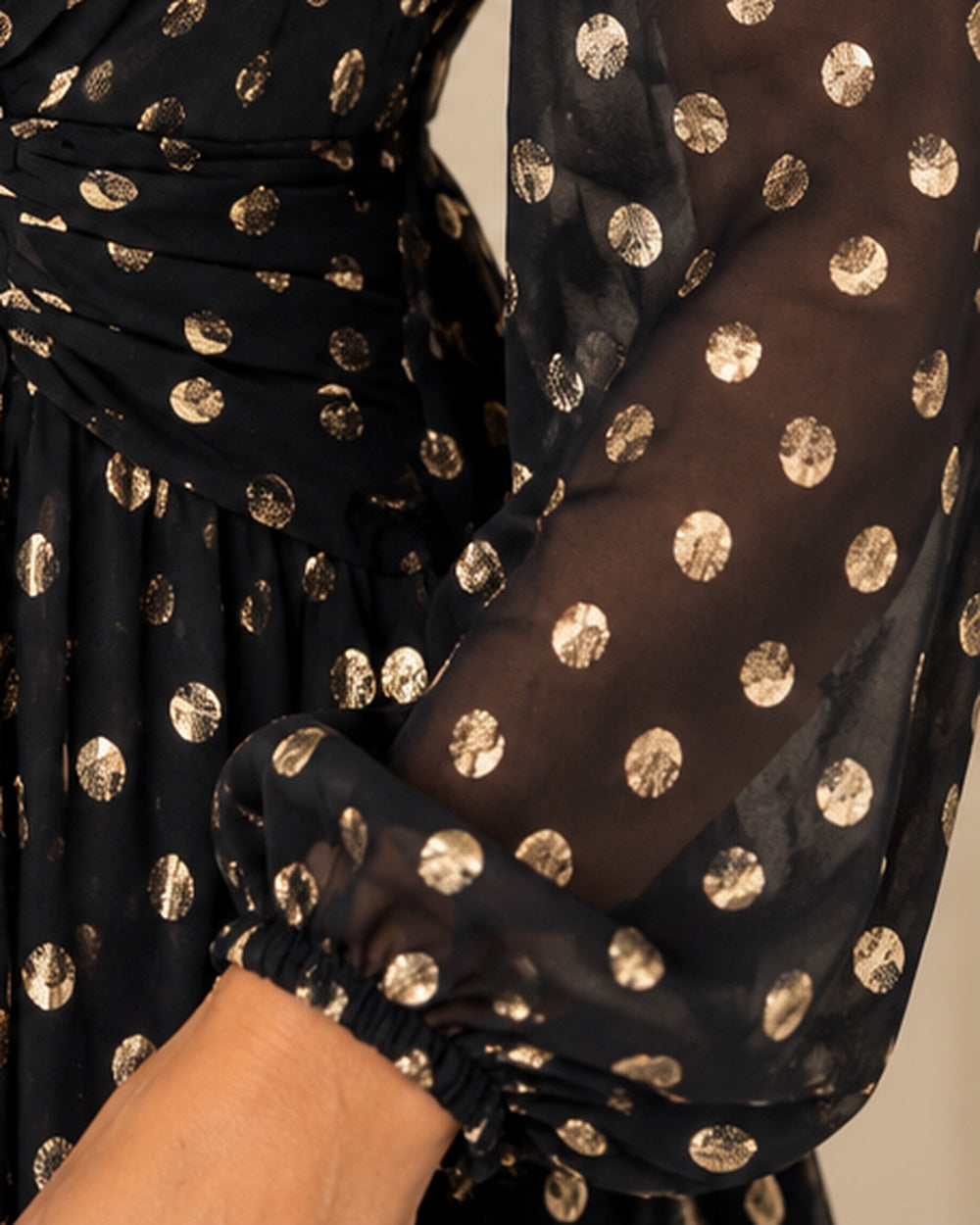 Robe CHIARA noire : détail de la manche en voile transparent à pois dorés