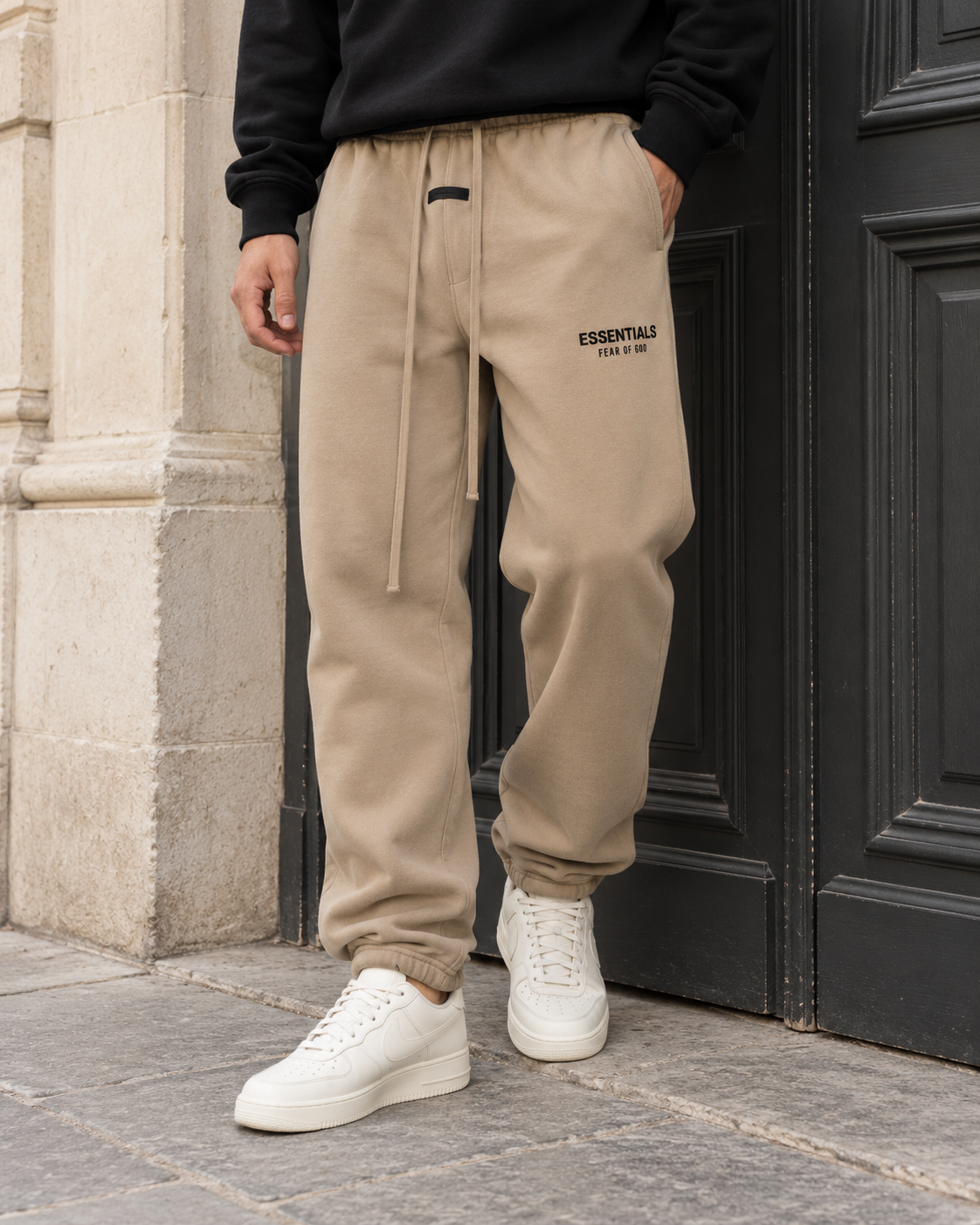 Jogging Sohan sable Fear of God Essentials 130HO242027F porté avec un sweat noir dans un look streetwear.